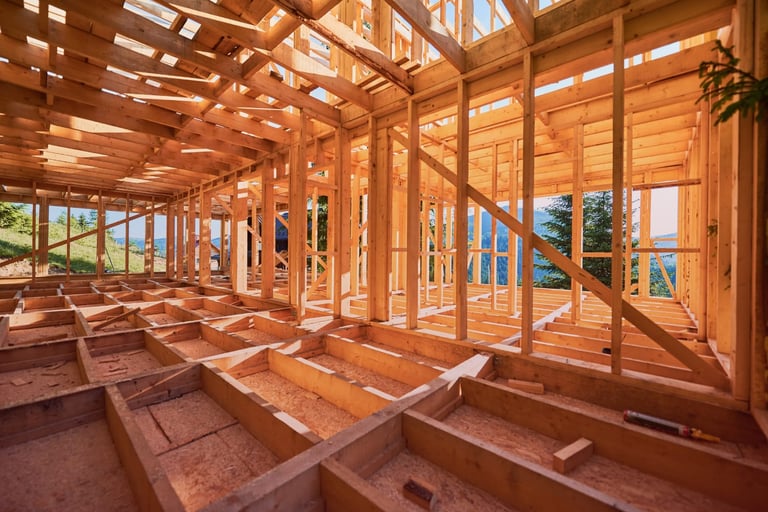 Wooden framing of a house under construction with mountain views