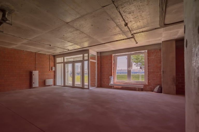 Empty unfinished room with exposed brick and concrete ceiling
