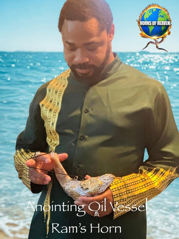 Man holding a silver ram's horn vessel at the beach.