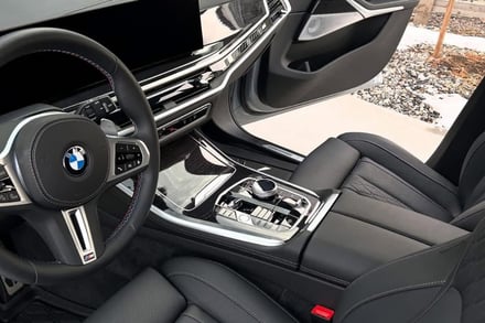 Pristine luxury BMW interior detailing with glossy carbon fiber accents.