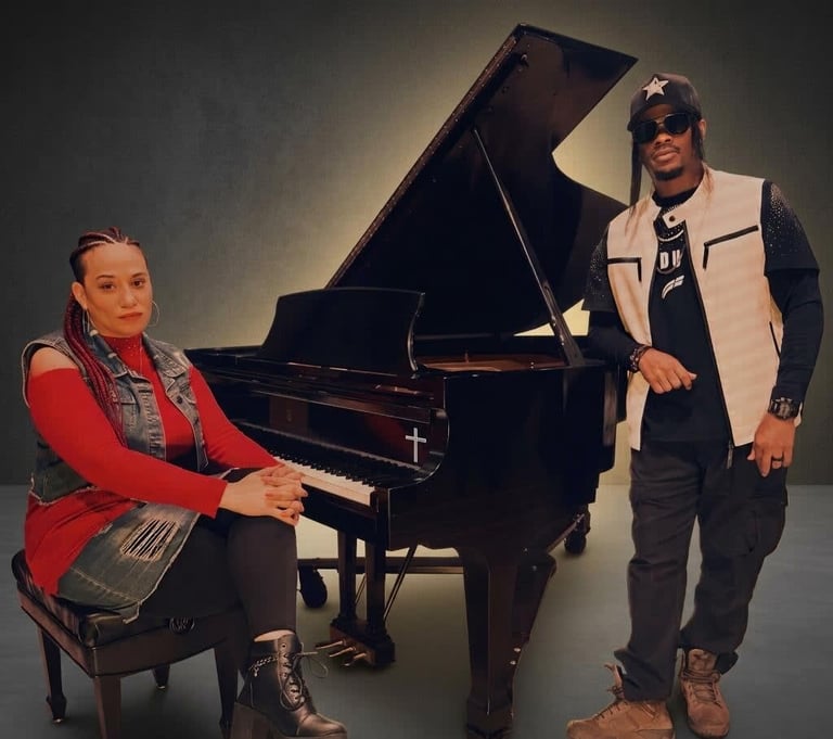 Two musicians pose beside a grand piano in a studio setting.