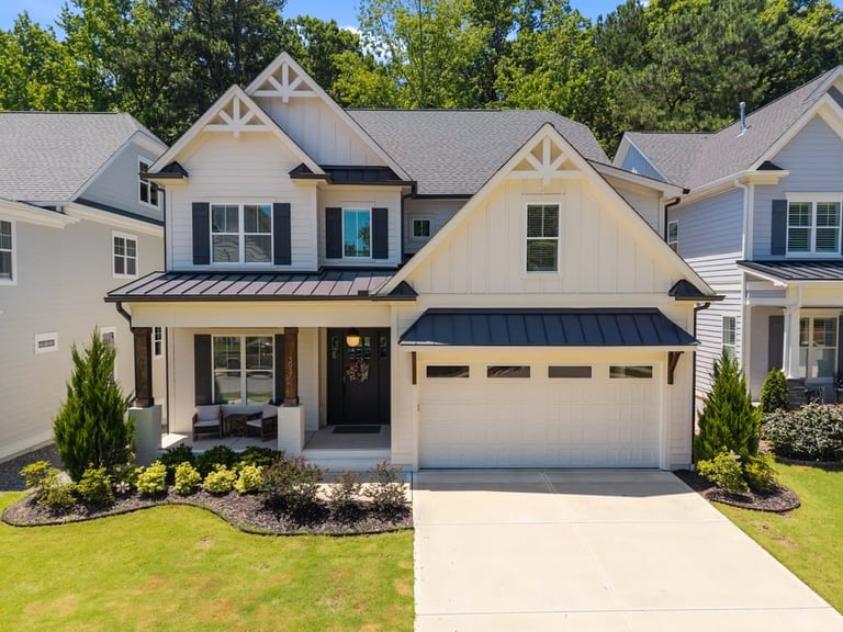 Modern two-story house with dark trim and garage, front yard landscaping.