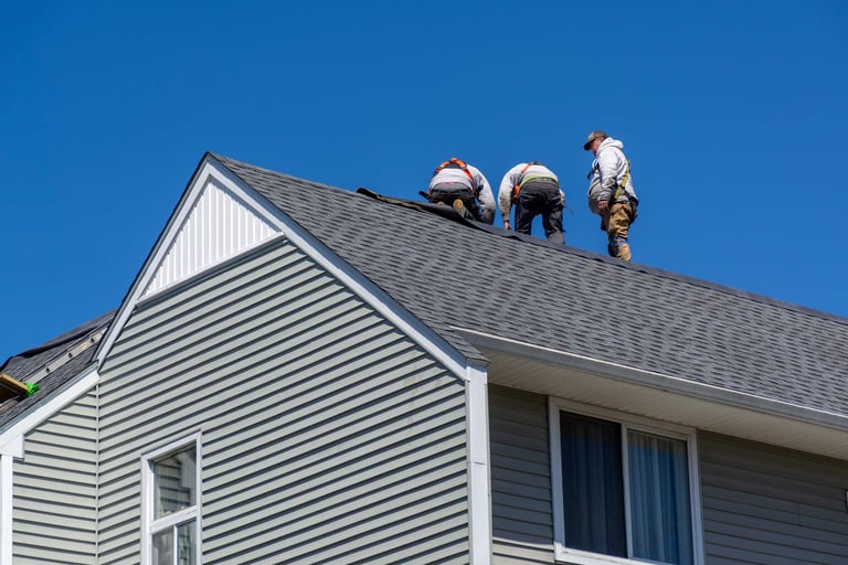 Professional roofers performing maintenance on a gable roof house in Brighton, Boston, Massachusetts, USA