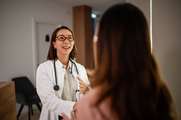 Female doctor talking to patient, explaining treatment options during a consultation. Healthcare professional advising on wellness