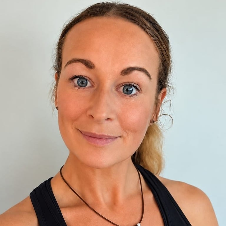 A woman with blue eyes and pulled-back hair smiles at the camera.