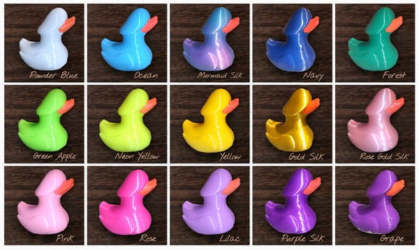 Grid of colorful rubber ducks labeled with names on a dark wood surface.