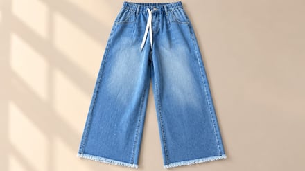 Wide-leg denim jeans with drawstring waist and frayed hems laid flat.