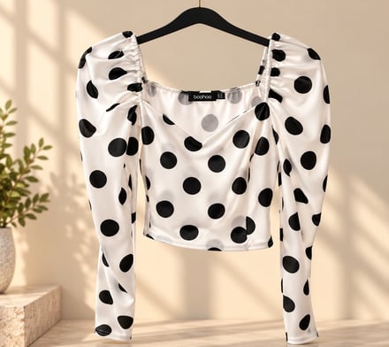 Polka dot crop top on a hanger in a sunlit room.