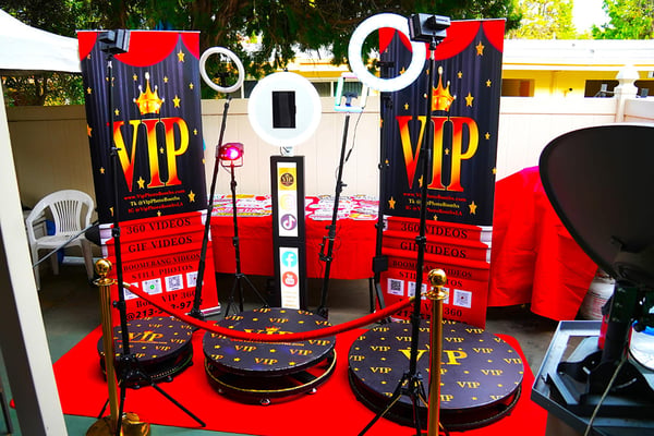 VIP photo booth setup with ring lights and red carpet props.