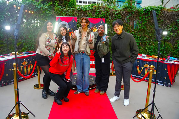 Group of friends posing on a red carpet at an event