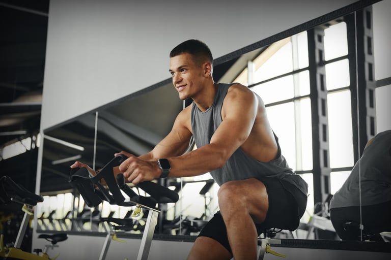 Man cycling on stationary bike in modern gym