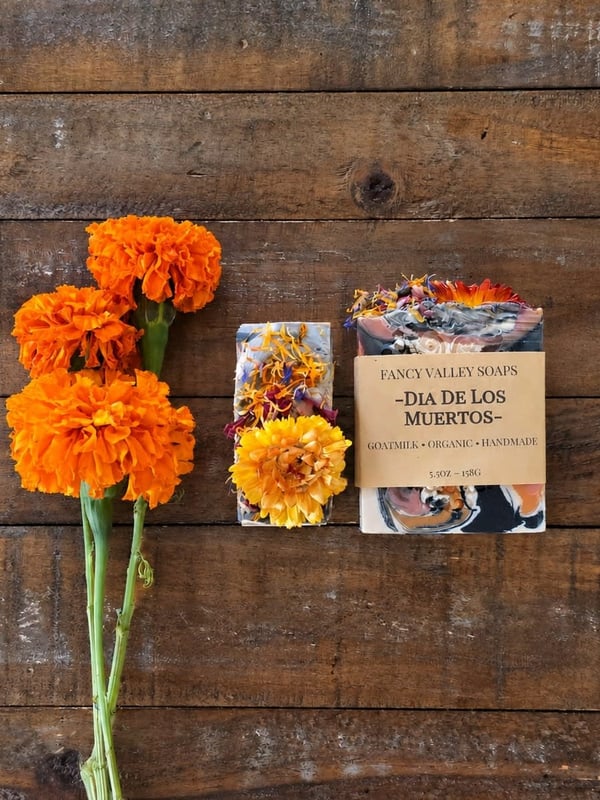 Handmade soap and marigolds on weathered wood for Dia de los Muertos