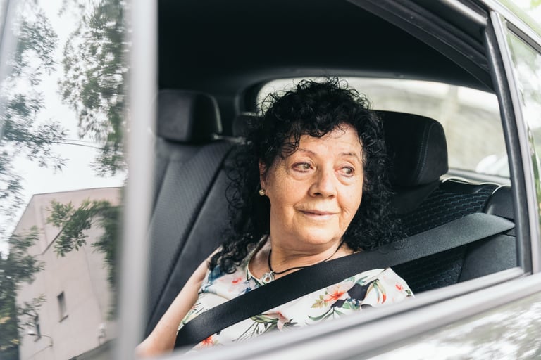 Senior woman smiling and looking out the window while traveling by car