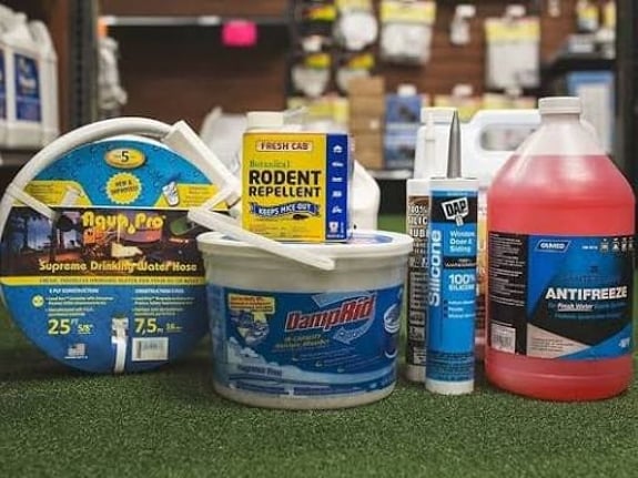A collection of pest control and home maintenance products on artificial turf.